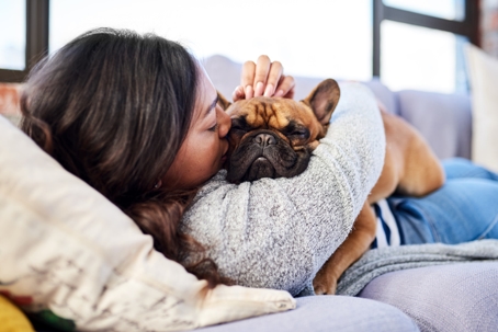 woman kissing pet dog