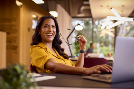 happy businesswoman working on her laptop in an office