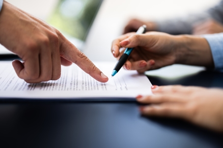person signing a document with a lawyer