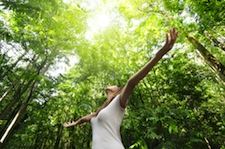 woman arms spread out in forest